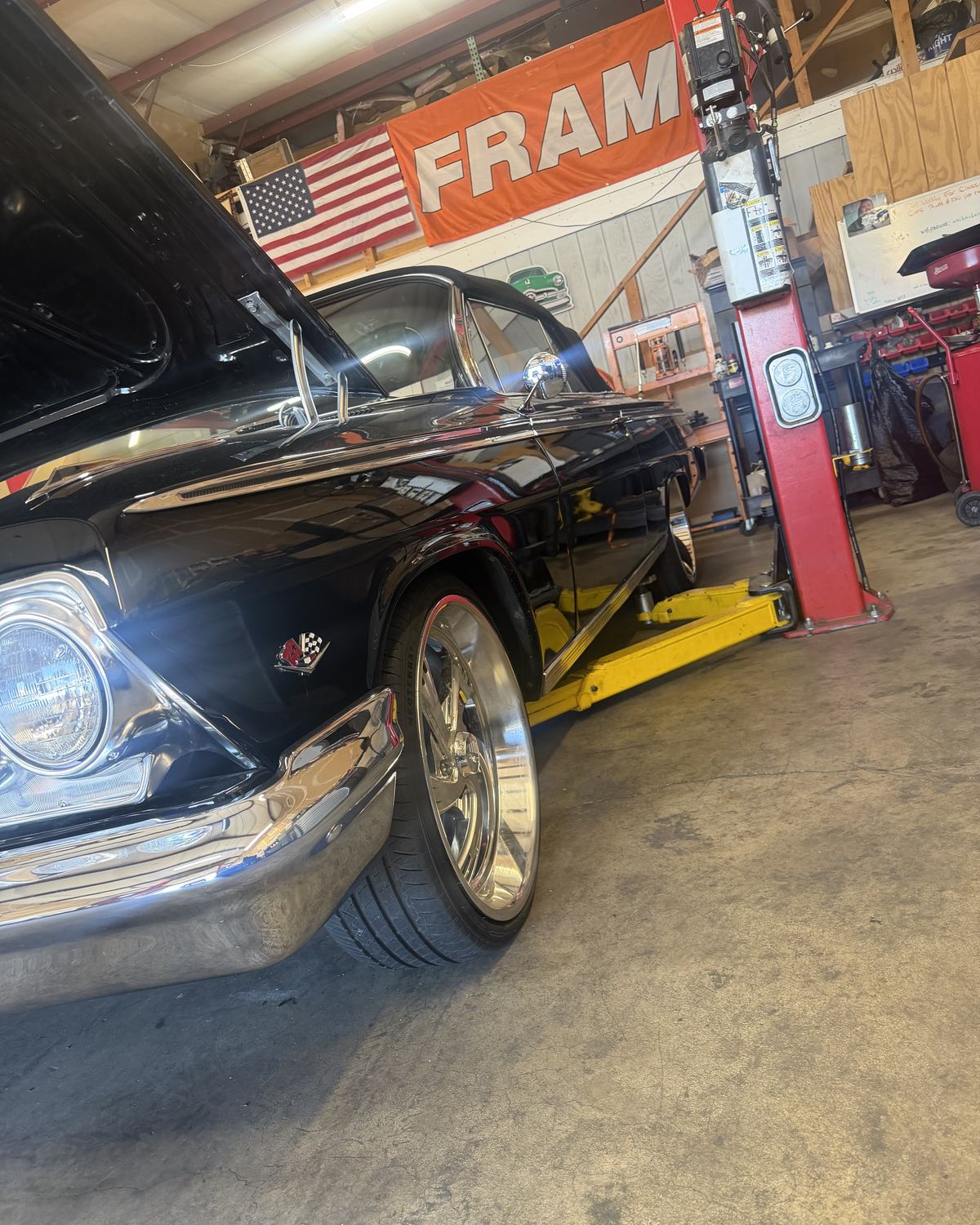 A black classic Chevrolet with chrome wheels in the bay at Ronnie’s Automotive in Sacramento